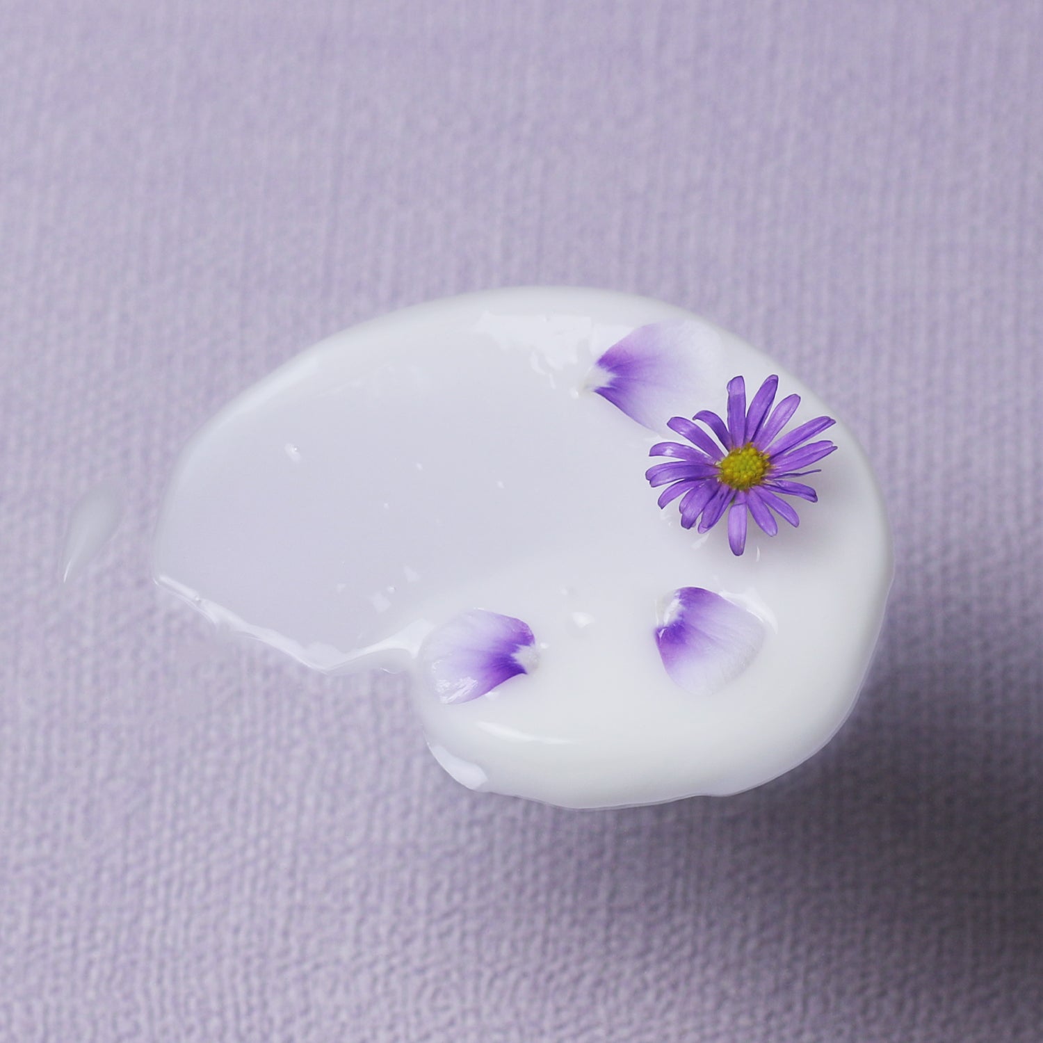 A swatch of Bakuchiol Smoothing Serum  with tiny flowers and petals