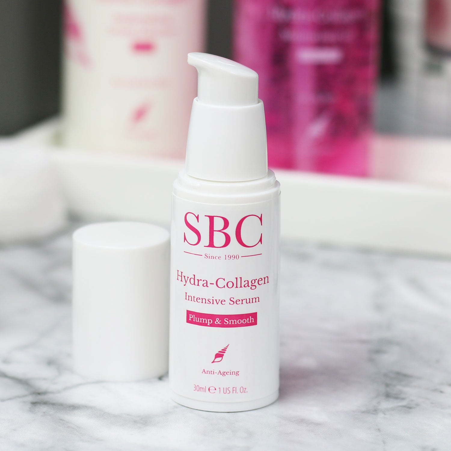 Hydra-Collagen Intensive Serum with it's cap off on a marble counter