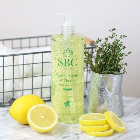 500ml Lemon Myrtle & Thyme Moisturising Gel on a marble counter with lemon slices and a pot of thyme