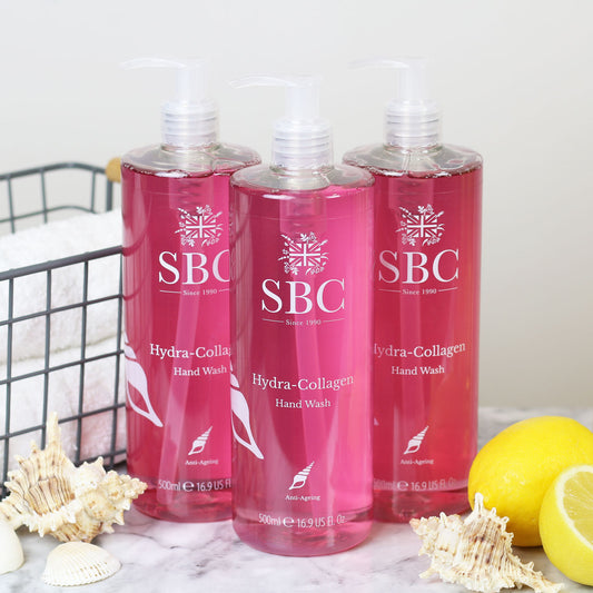 Three 500ml Hydra-Collagen Hand Washes on a marble counter with shells