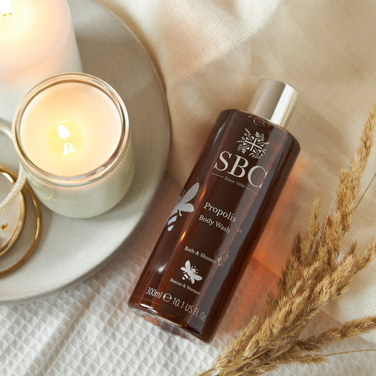 Propolis Body Wash, with a candle and dried flowers