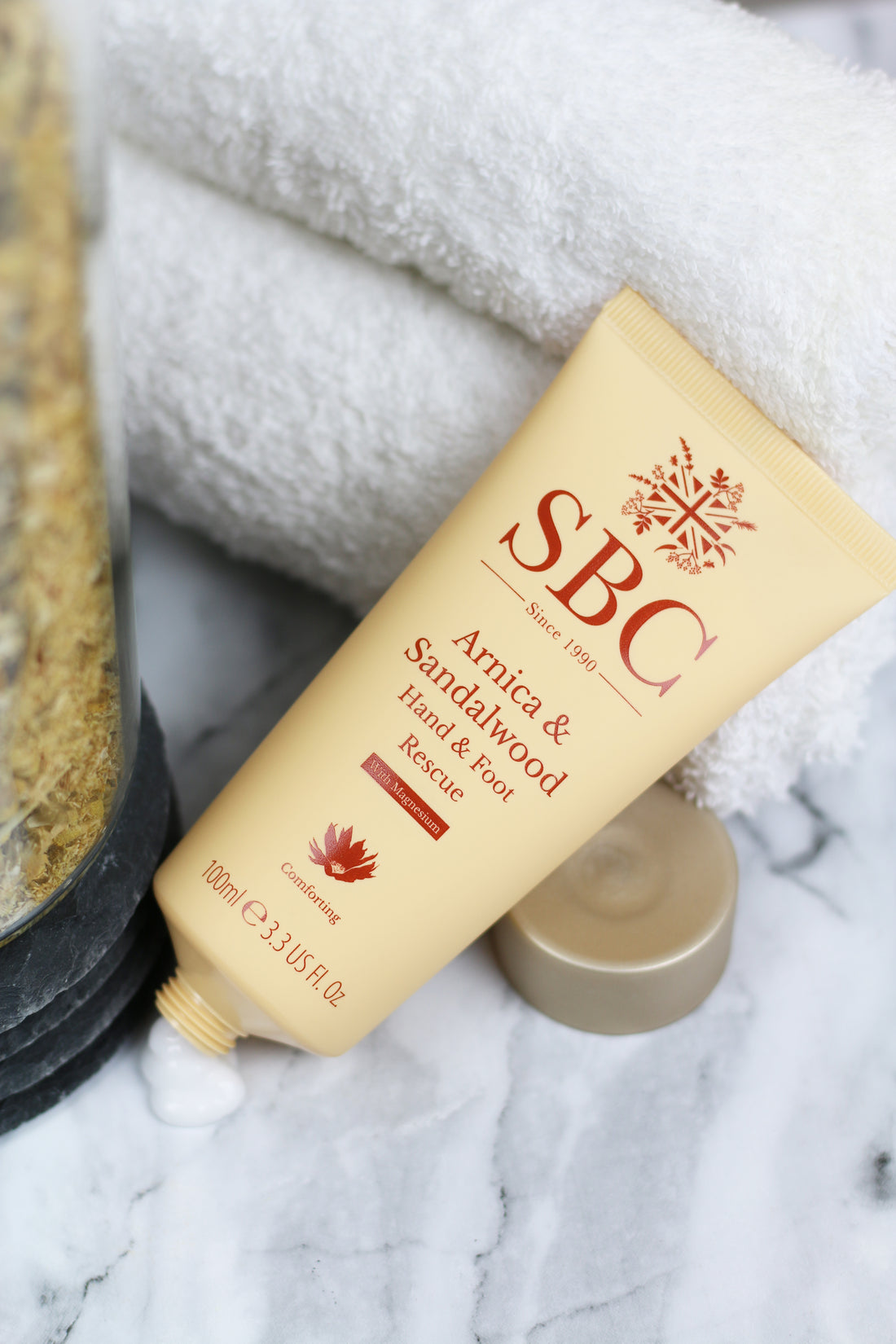 SBC Skincare's Arnica & Sandalwood Hand & Foot Rescue on a marble table