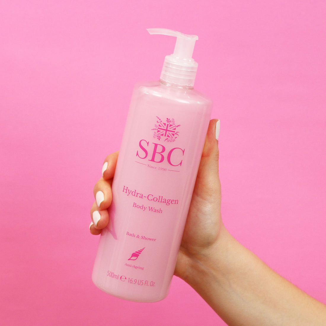 hand holding Hydra-Collagen Body Wash in front of a pink background