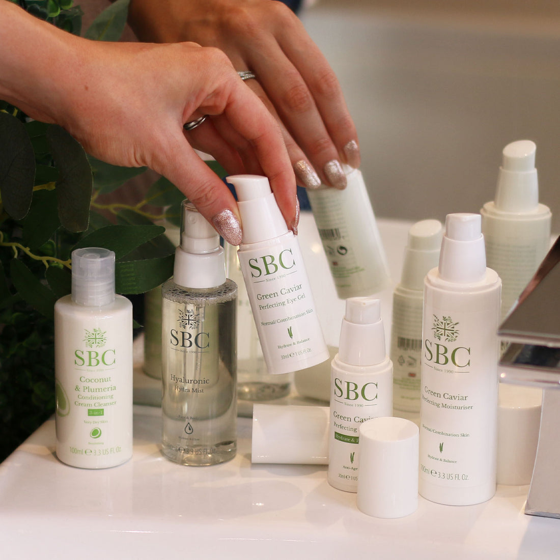 SBC Skincare's Vegan Products with a hand selecting Green Caviar Perfecting Serum