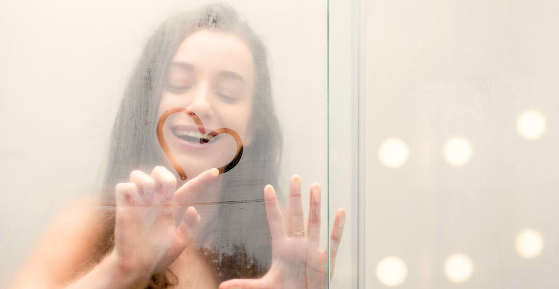 woman in shower drawing heart