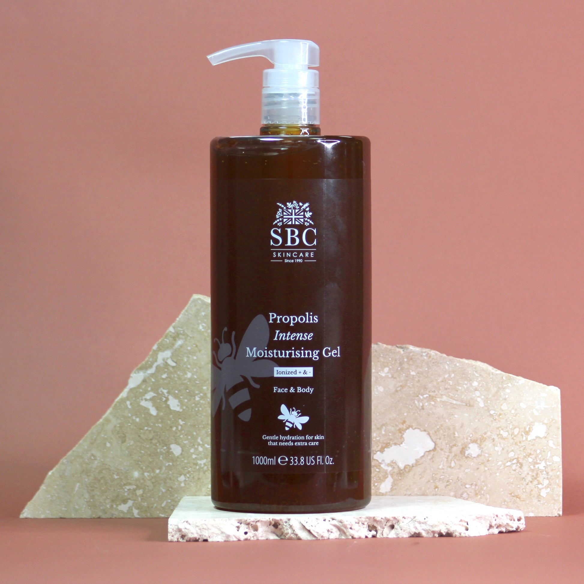 SBC Propolis Intense 1000ml Moisturising Gel set against a pinkish background and parts of broken tile in an artistic lifestyle image