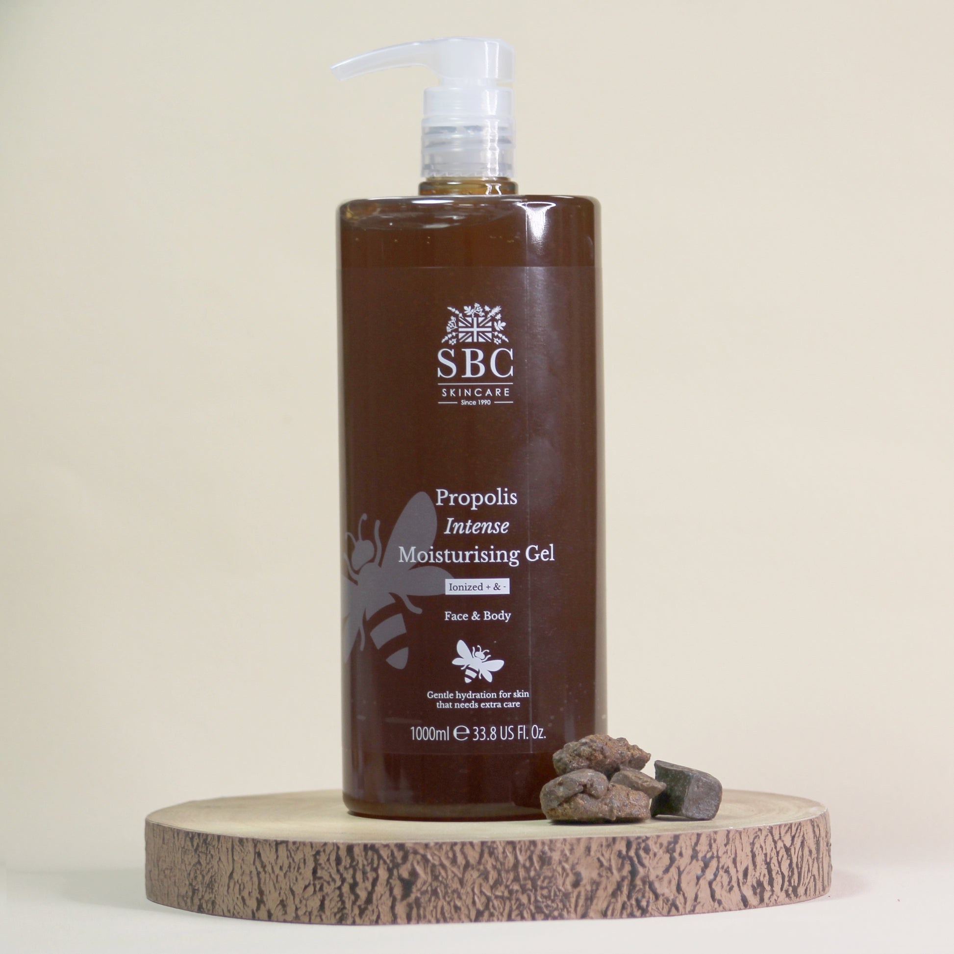 1000ml brown bottle of SBC Propolis Moisturising Gel on a wooden stand with a beige background