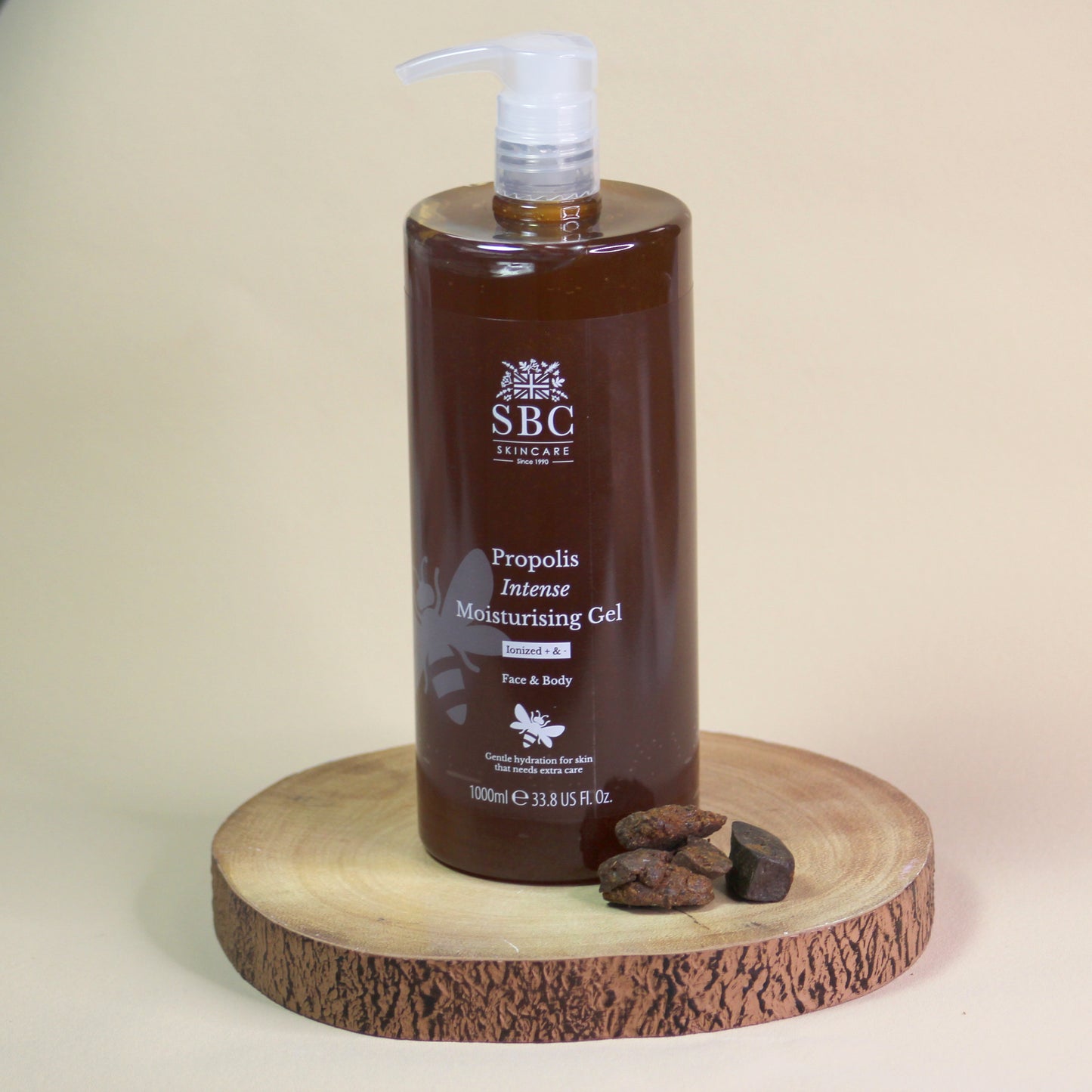 Brown bottle of 1000ml SBC Propolis Intense Moisturising Gel on a wooden stand with a beige background