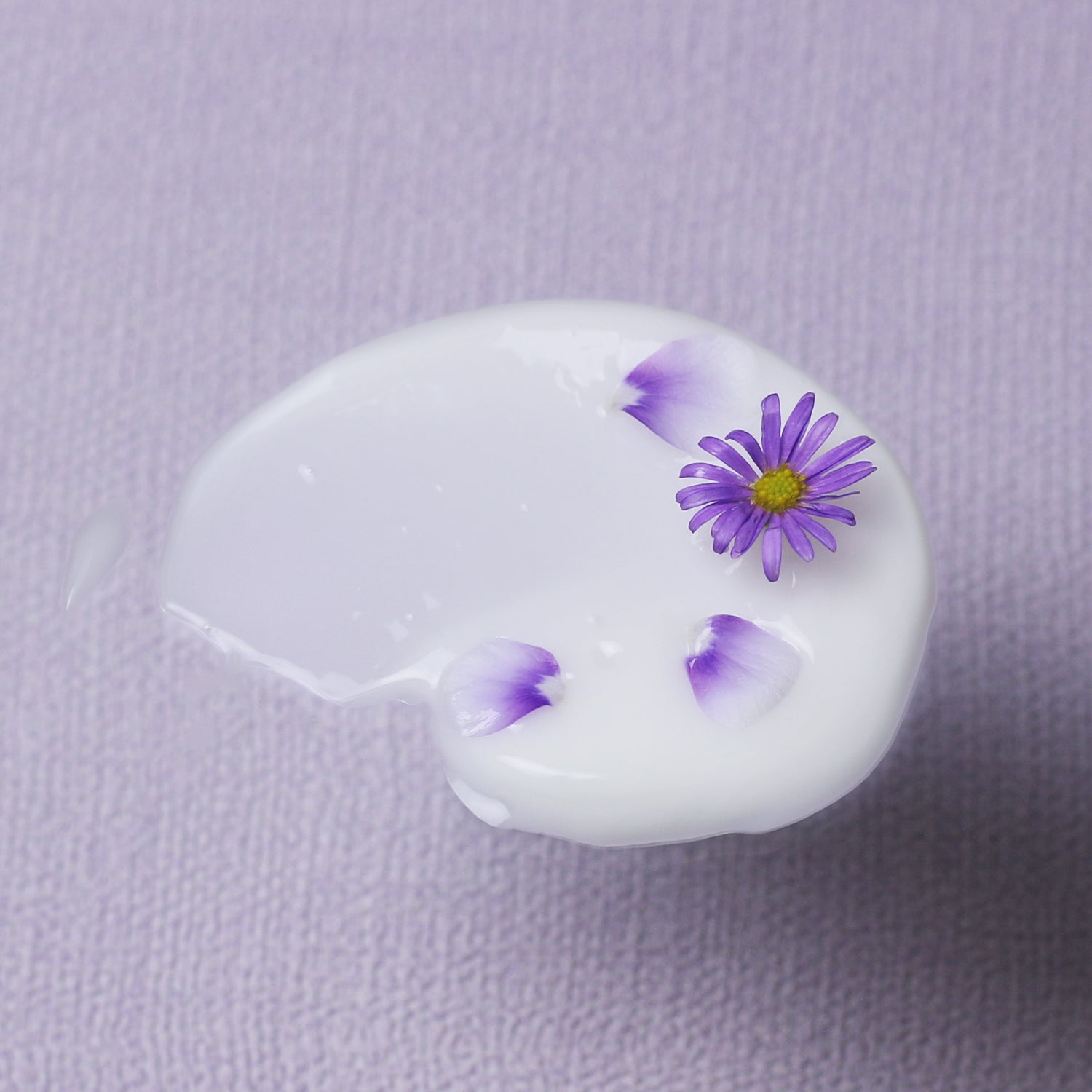 A swatch of Bakuchiol Smoothing Serum  with tiny flowers and petals 
