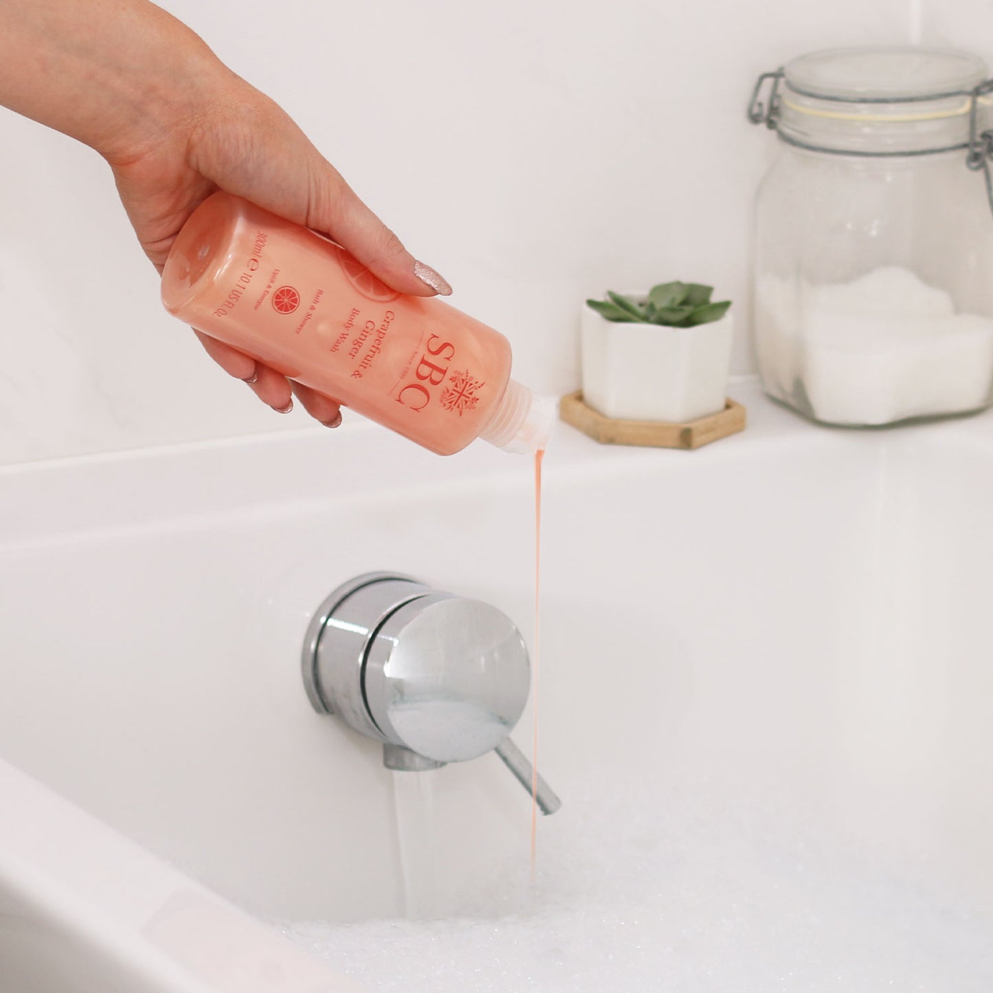 SBC Skincare's Grapefruit & Ginger Body Wash being poured into a running bath 