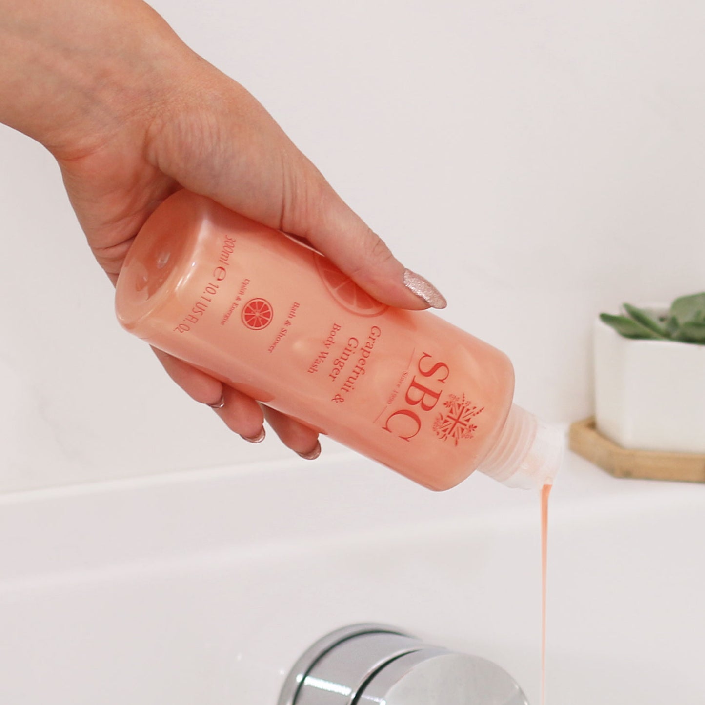 Close up of Grapefruit & Ginger Body Wash being poured into a bath