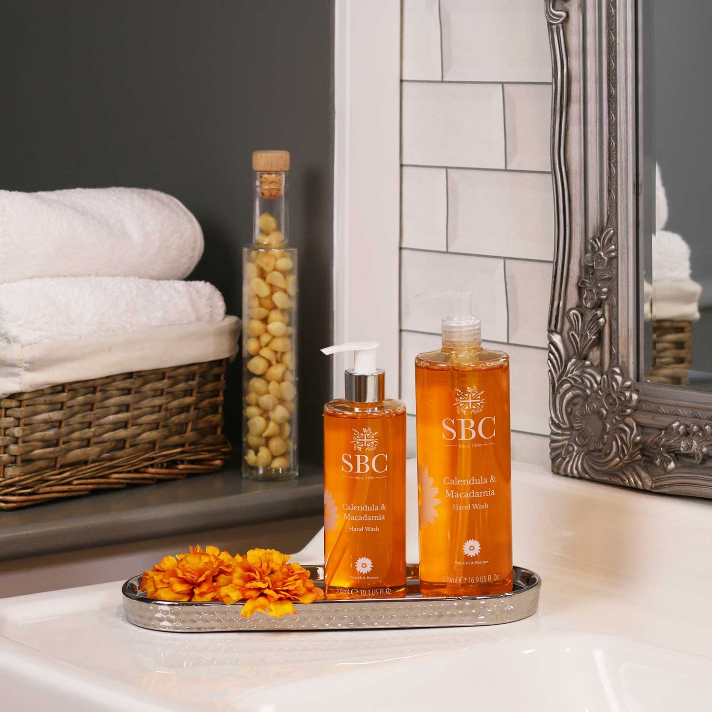 500ml and 300ml Calendula & Macadamia Hand Wash in a silver dish on a bathroom sink