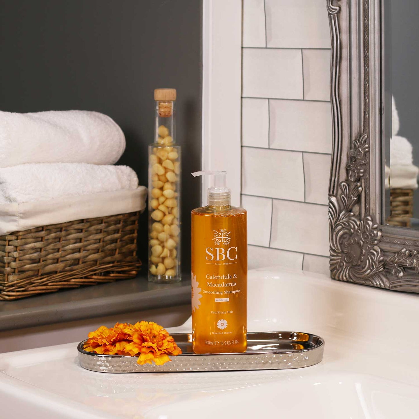 500ml Calendula & Macadamia Smoothing Shampoo in a silver dish on a bathroom sink