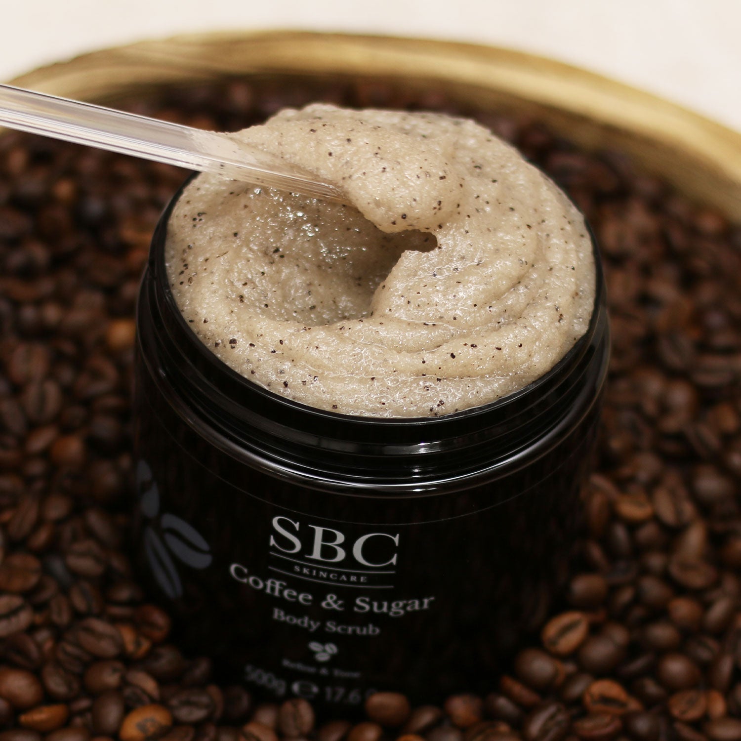 Coffee & Sugar Body Scrub being mixed by a plastic spatula 