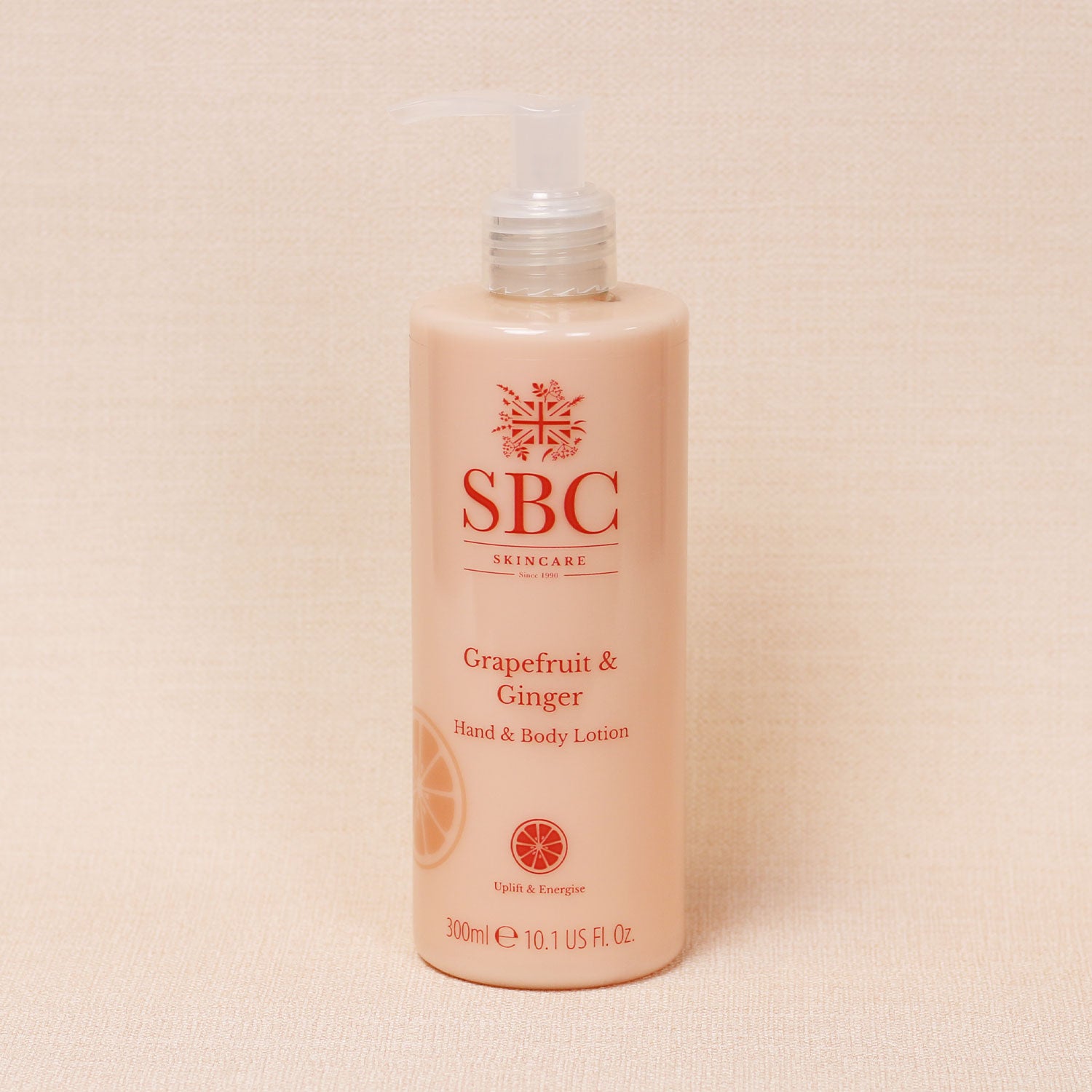 Grapefruit & Ginger Hand & Body Lotion on a textured peach background 