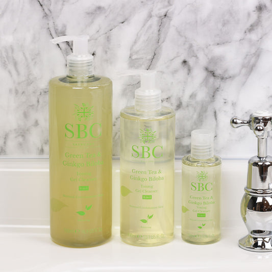 100ml, 300ml and 500ml of the SBC Skincare Green Tea & Ginkgo Biloba Toning Gel Cleanser on a sink with a marble splash back