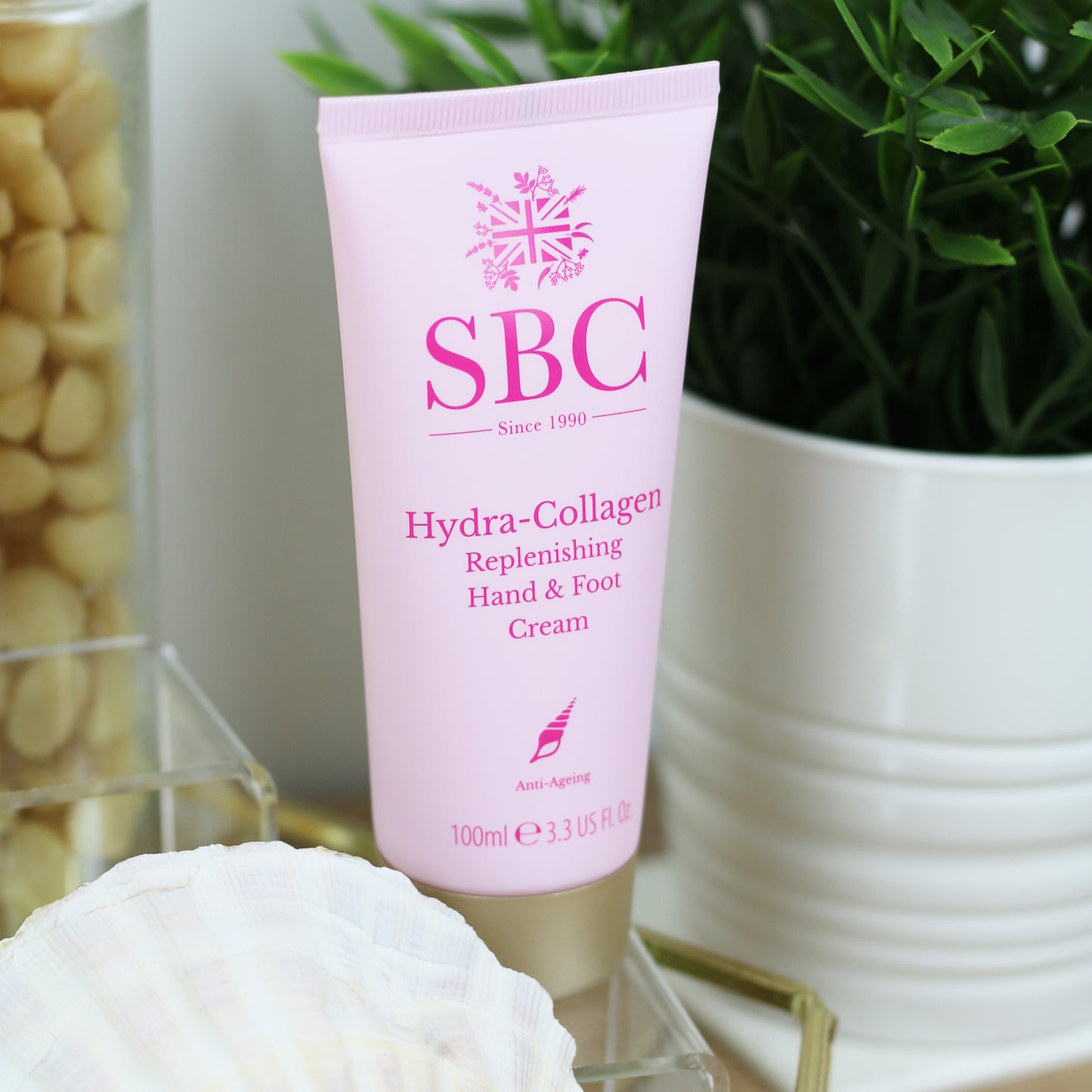 Hydra-Collagen Hand & Foot Cream in front of a plant in a white pot