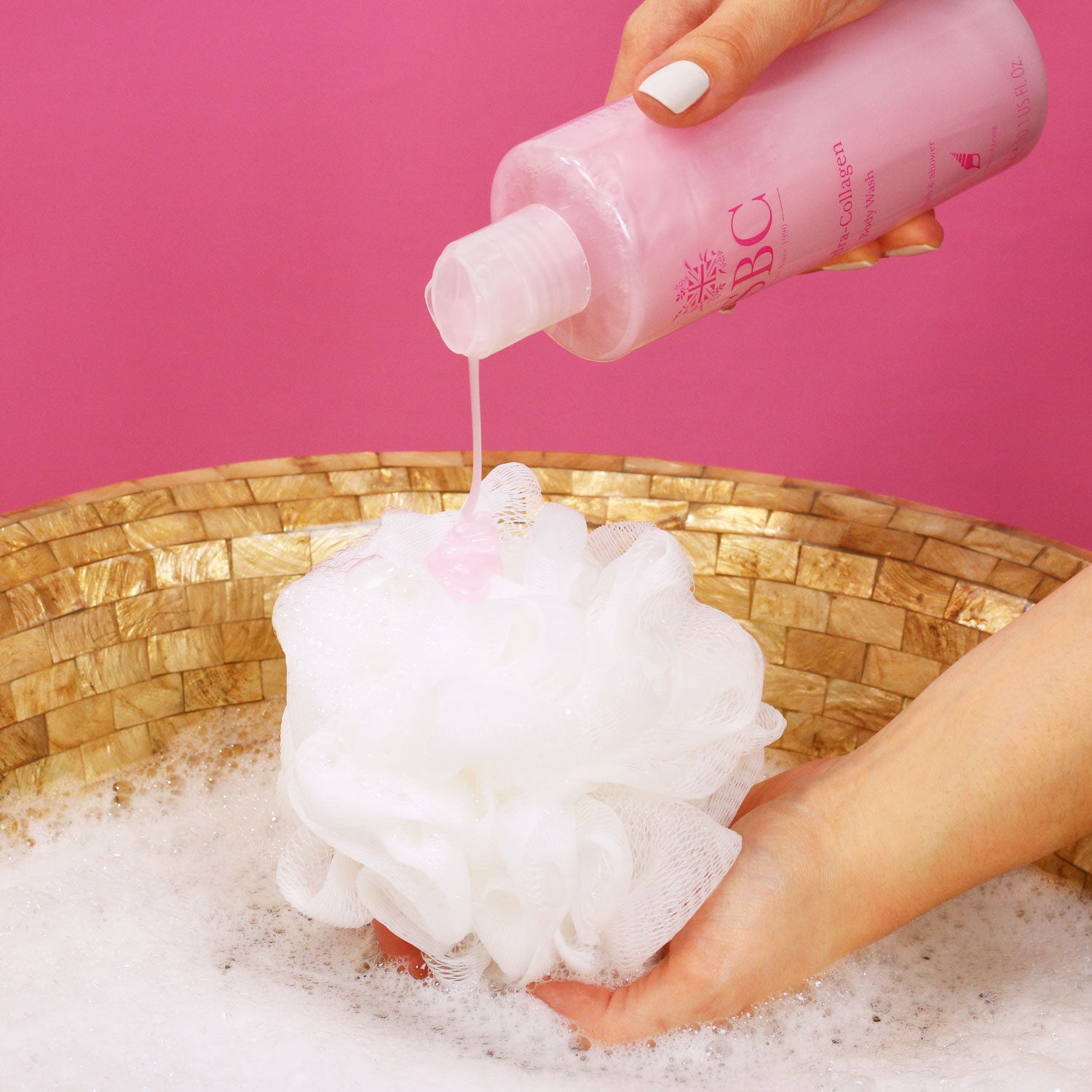 SBC Skincare's Hydra-Collagen Body Wash  being poured onto a shower scrunchie 