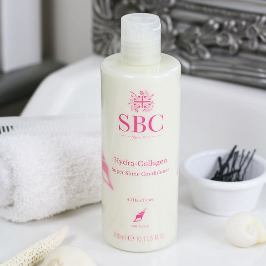 300ml Hydra-Collagen Super Shine Conditioner on a bathroom sink with some hair grips and a towel