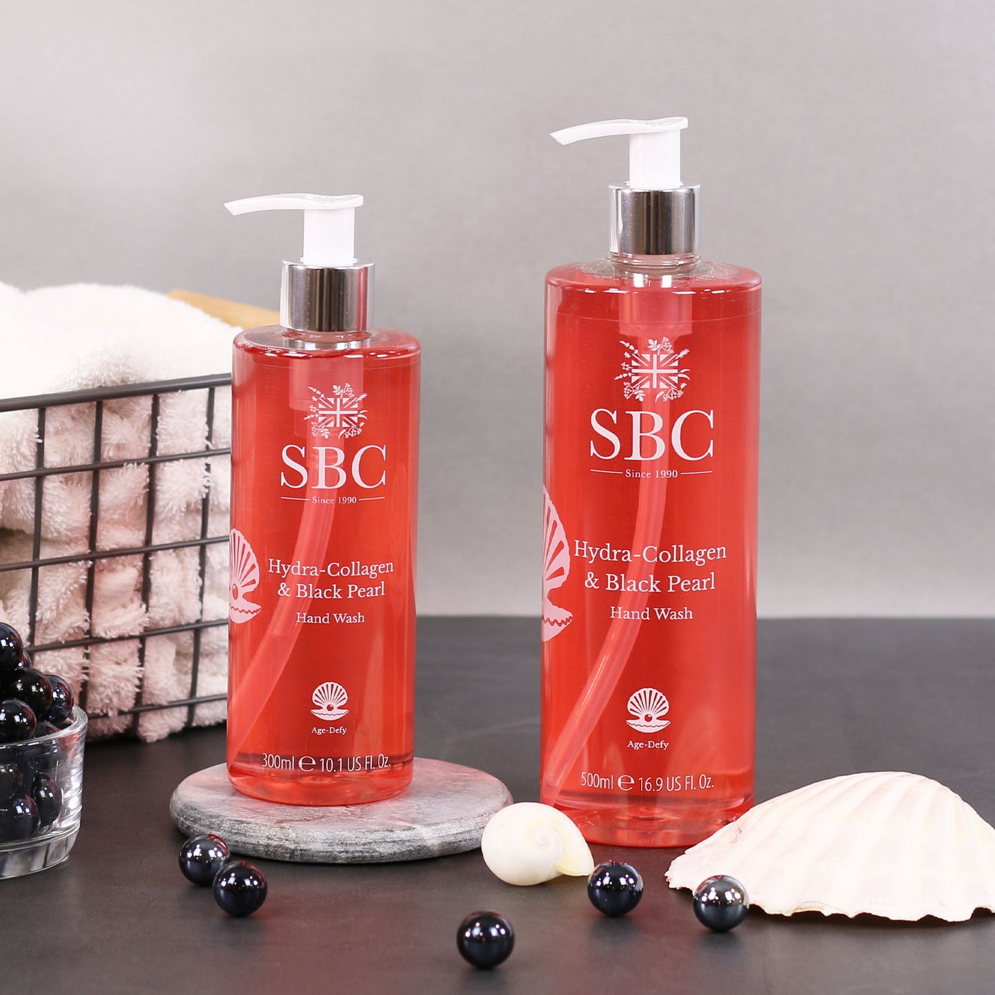 300ml and 500ml Hydra-Collagen & Black Pearl Hand wash on a grey background with black pearls