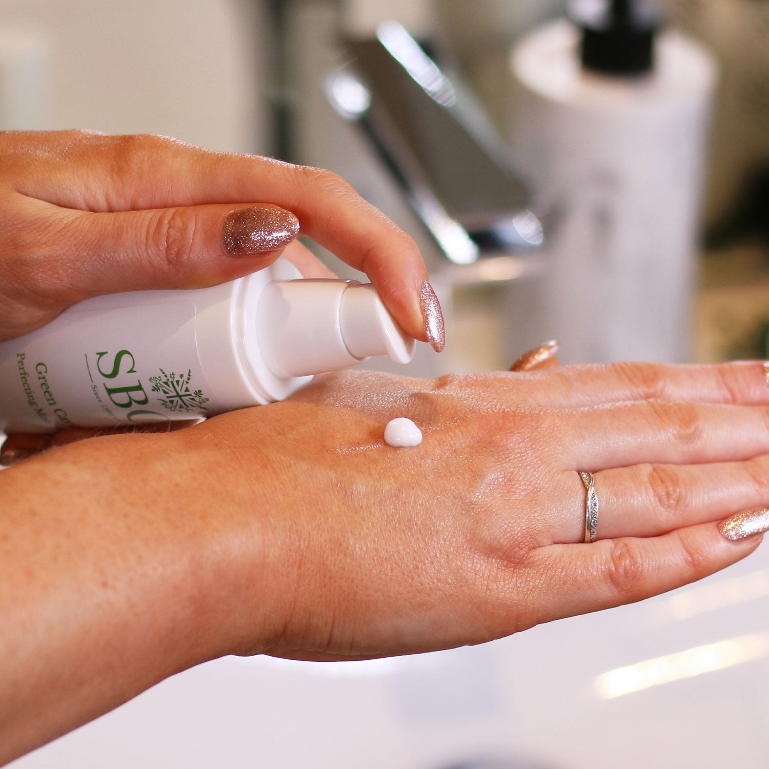 Green Caviar Perfecting Moisturiser being pumped onto the back of a hand 