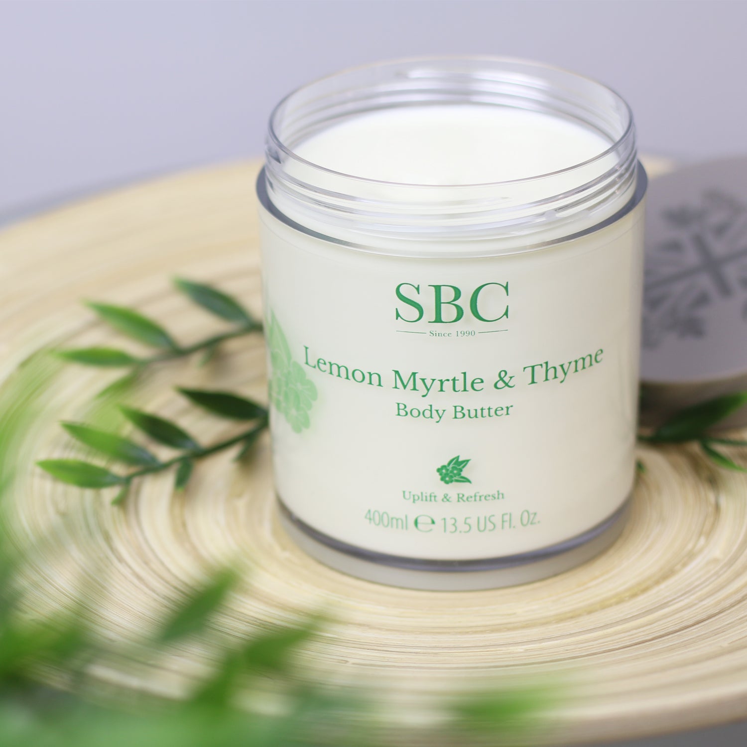 Lemon Myrtle & Thyme Body Butter on a wooden plate with leaves
