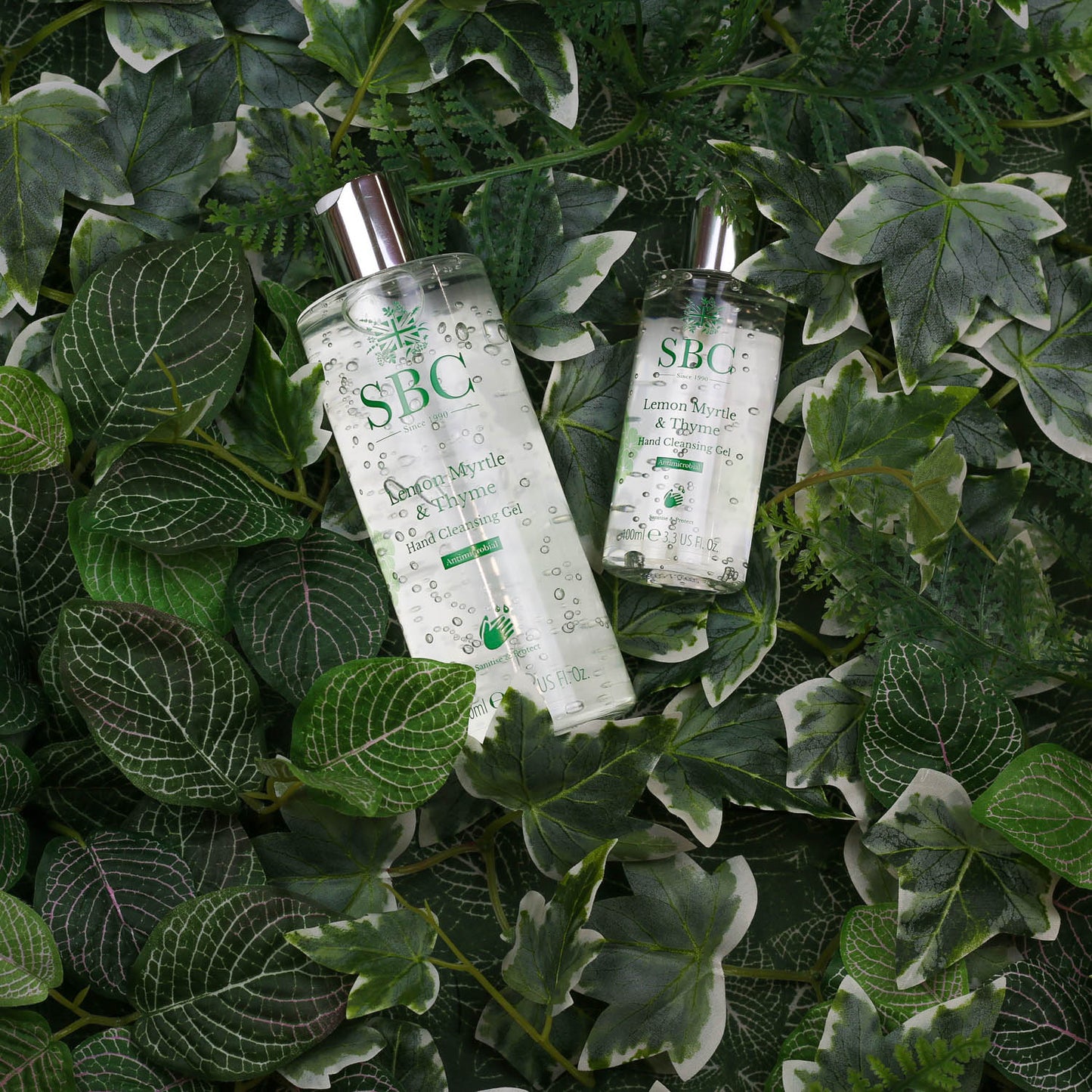 100ml and 300ml Lemon Myrtle & Thyme Hand Cleansing Gel on a bed of leaves 