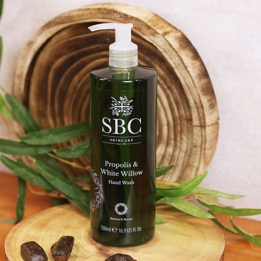 Propolis & White Willow Hand Wash on a wooden slice with white willow leaves and propolis extract