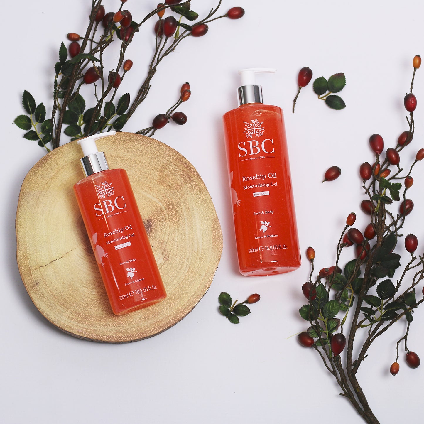 300ml and 500ml Rosehip Oil Moisturising Gel on a log slice with rosehips 