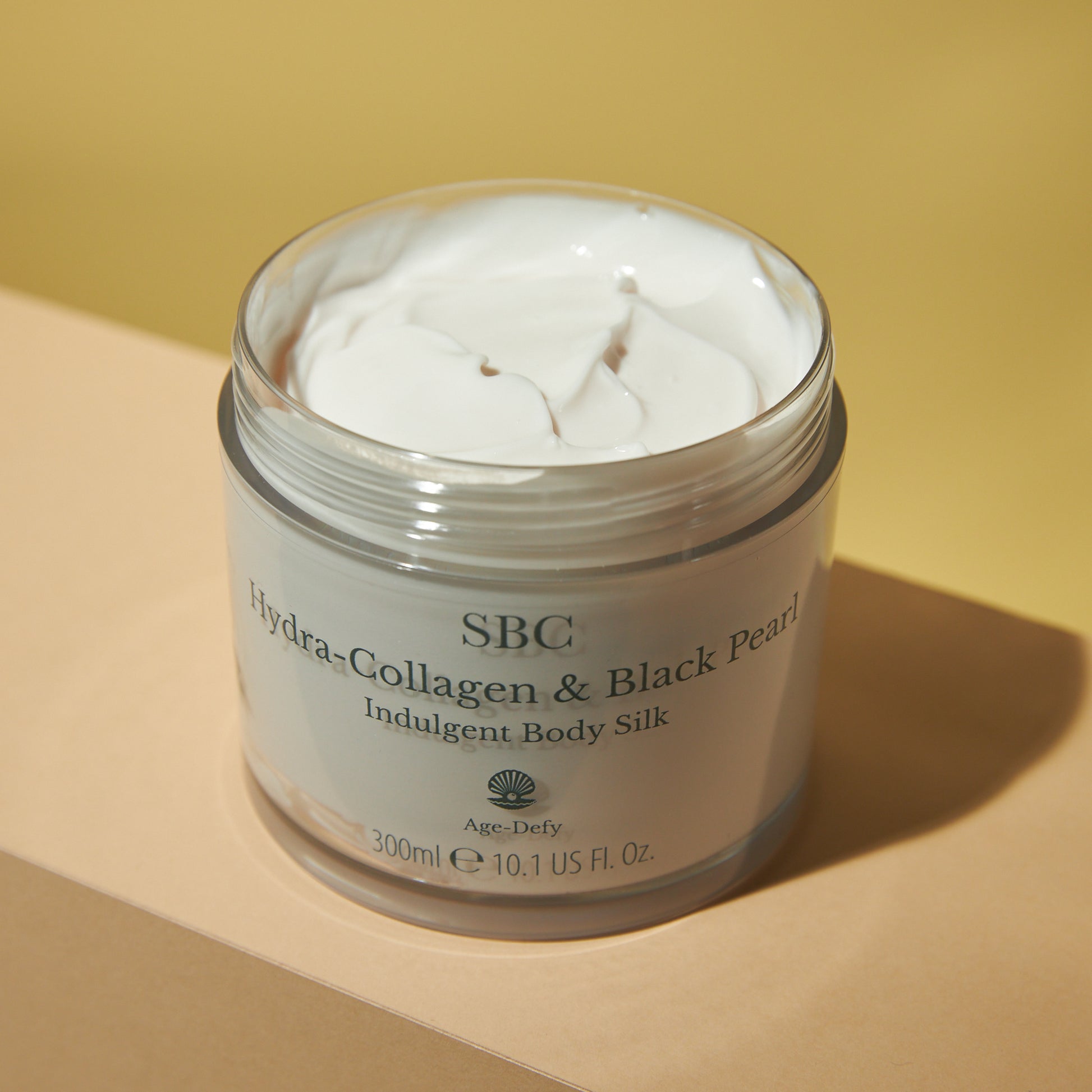 Hydra-Collagen & Black Pearl Indulgent Body Silk  on a counter with natural light 