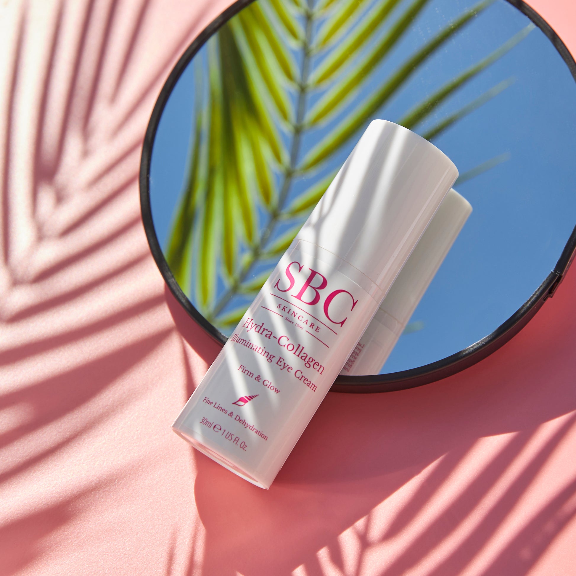 Hydra-Collagen Illuminating Eye Cream on a mirror with palm leaf shadows 