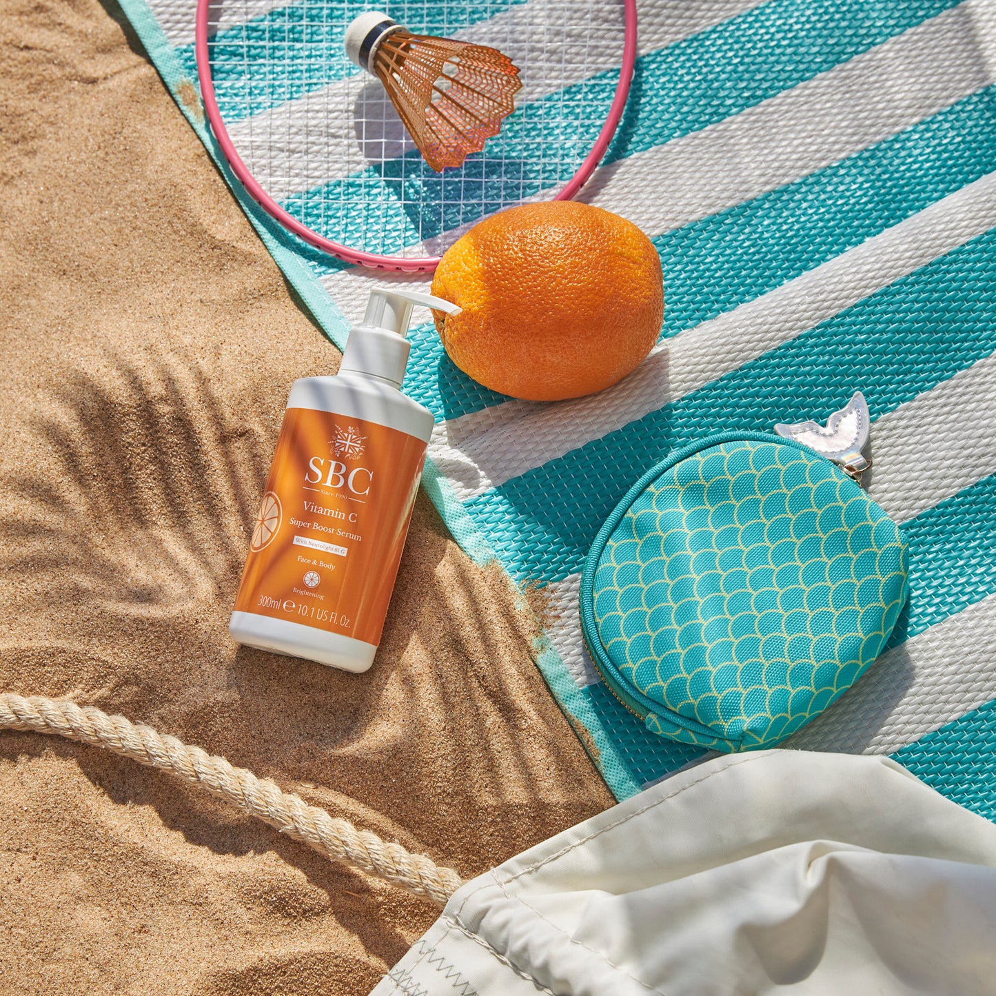 Vitamin C Super Boost Serum on a beach towel in the sand