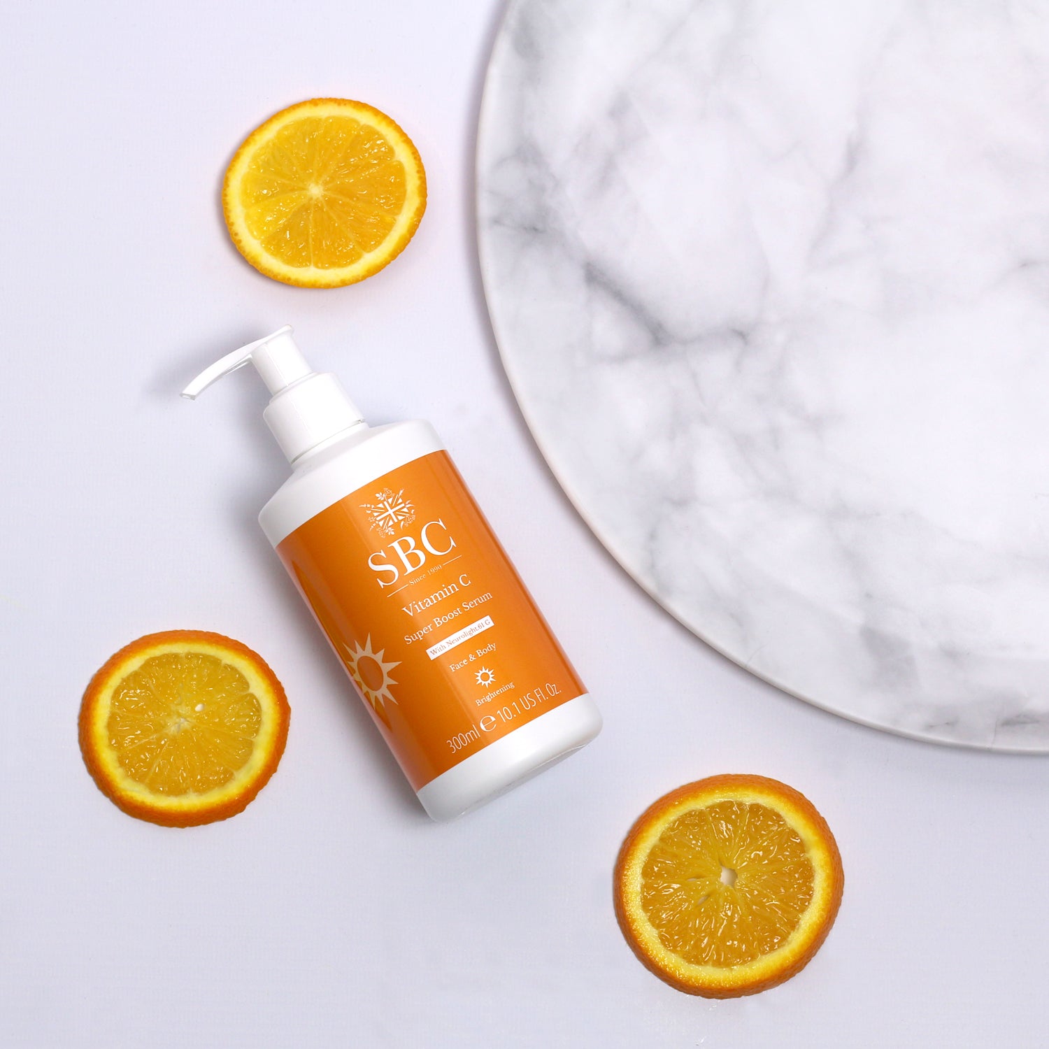 Vitamin C Super Boost Serum with a marble plate and slices of oranges