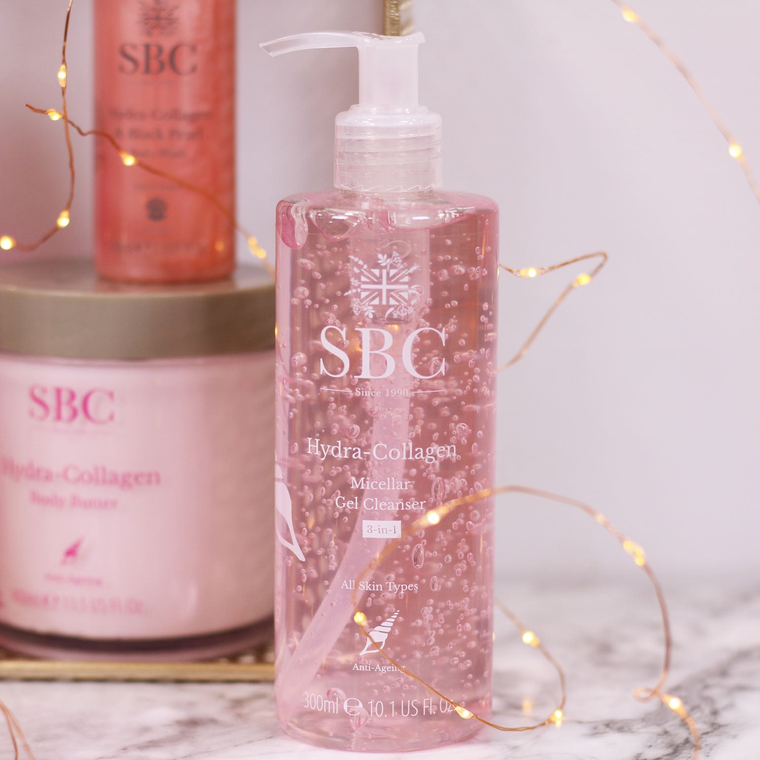 Hydra-Collagen Micellar Gel Cleanser on a marble counter with fairy lights 